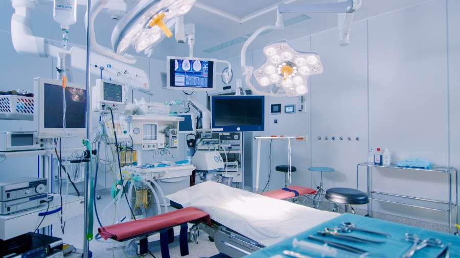 Operating room with medical equipment and supplies surrounding an operating table